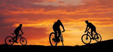 sagoma di un mountain biker godendo in discesa durante il tramonto. concetto di mountain bike. gara di mountain bike - ciclista silhouette sullo sfondo. foto