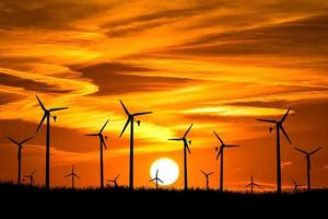 le turbine eoliche producono elettricità la sera. tramonto, silhouette, mulini a vento, energia pulita la sera. alternativa di concetto rinnovabile ed energia pulita ed eolica foto