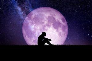 uomo disperato e solitario sullo sfondo della luna di notte. concetti disperati, strazianti e solitari foto