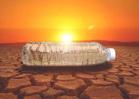 concetto di scarsità d'acqua siccità a causa del riscaldamento globale. bottiglie d'acqua poste in aree di siccità e terreno rotto foto