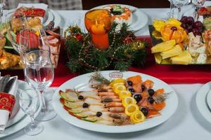 bella tavola festiva servita per la cena di celebrazione del matrimonio a casa o all'interno del ristorante. tavola piena di cibo in un ristorante. tavola rotonda completa. foto