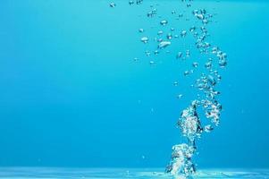 immagine di sfondo astratto di bolle in acqua. acqua pulita con gocce d'acqua e onde. acqua dolce un bicchiere con bolle sfondo blu. foto