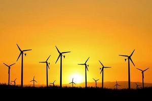 le turbine eoliche producono elettricità la sera. tramonto, silhouette, mulini a vento, energia pulita la sera. alternativa di concetto rinnovabile ed energia pulita ed eolica foto