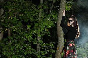 ritratto di donna vampiro di halloween su sfondo notte spaventosa. vampiro trucco fashion art design. ragazza modello in costume di halloween e trucco. foto