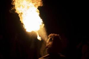 ragazzo spara dalla sua bocca. uomo e fiamma. uomo sputafuoco. fiamma brillante. foto