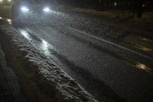 auto di notte nella neve. veicoli su strada con i fari accesi. foto