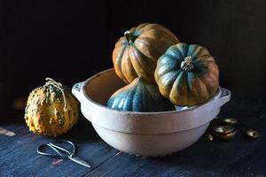 zucca di ghianda arancione e verde in una ciotola di fattoria in un ambiente rustico foto