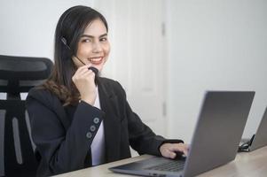 agente di call center femminile con auricolare che consulta i clienti online, servizio clienti e concetto di operatore di assistenza clienti foto