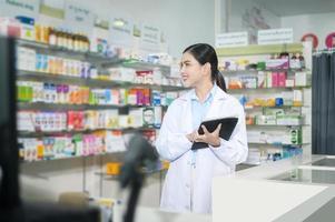 ritratto di farmacista donna che utilizza tablet in una moderna farmacia farmacia. foto