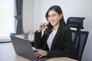 agente di call center femminile con auricolare che consulta i clienti online, servizio clienti e concetto di operatore di assistenza clienti foto