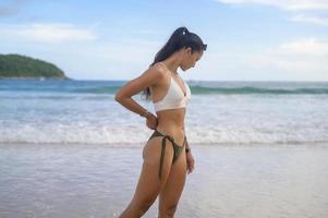 giovane bella donna in bikini godendo e rilassarsi sulla spiaggia, estate, vacanze, vacanze, concetto di stili di vita. foto