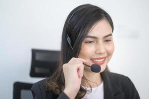 agente di call center femminile con auricolare che consulta i clienti online, servizio clienti e concetto di operatore di assistenza clienti foto