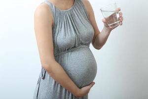 donna incinta che beve dell'acqua foto