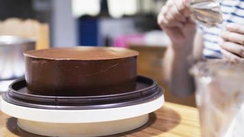 signora che fa la torta al cioccolato - persone con il concetto di panetteria fatta in casa foto