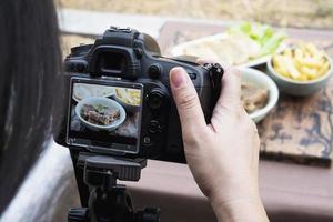 persone che utilizzano la fotocamera digitale per scattare fotografie di cibo o prodotti video