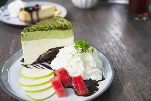 torta colorata di favore del tè verde con pezzi di frutta ben decorati e panna montata in un piatto bianco - concetto di menu della ricetta della torta foto