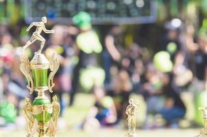 trofeo sportivo sulla sfocatura delle persone affollate nel festival della giornata sportiva della scuola foto