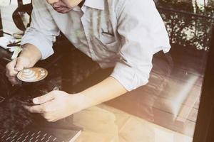 l'uomo d'affari sta lavorando con il suo computer nella caffetteria foto