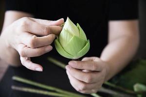 donna che prepara fiori di loto per adorare l'immagine del buddha - signora e fiori nel concetto di religione foto