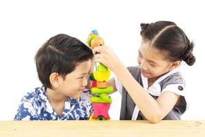 il ragazzo e la ragazza asiatici stanno giocando felicemente a un giocattolo colorato in blocchi di legno foto