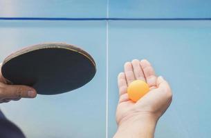 un uomo gioca a ping pong pronto a servire foto