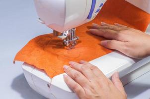 le mani della donna, cucendo il suo patchwork usando la macchina da cucire foto