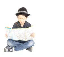 Il ragazzo asiatico di 7 anni è felicemente seduto e guardando una mappa. foto