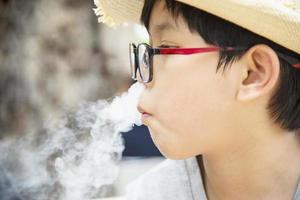 ragazzo asiatico che mangia felicemente fumante astuto - persone e spuntino concetto di tempo felice foto
