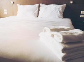 biancheria da letto bianca e set di asciugamani in un hotel moderno foto