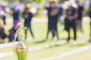 trofeo sportivo sulla sfocatura delle persone affollate nel festival della giornata sportiva della scuola foto