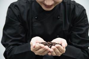 il barista asiatico sta usando il macinacaffè manuale per preparare il caffè caldo foto