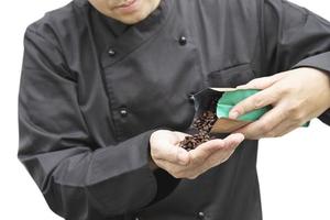 il barista asiatico sta usando il macinacaffè manuale per preparare il caffè caldo foto