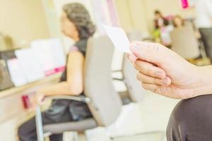 l'uomo tiene in mano la carta di coda mentre aspetta nella moderna area della reception foto