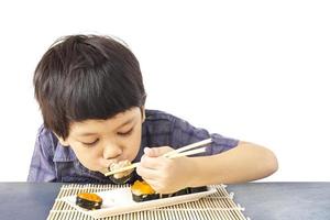 ragazzo adorabile asiatico sta mangiando sushi isolato su sfondo bianco foto