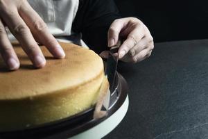 signora che fa la torta mettendo la crema con la spatola - concetto di cucina da forno fatto in casa foto