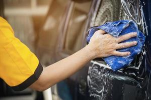 l'uomo lava l'auto usando lo shampoo - concetto di cura dell'auto per la vita quotidiana foto