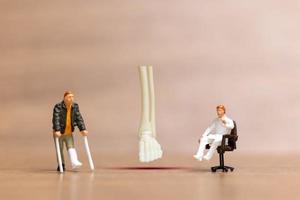 i pazienti con lesioni alle gambe di persone in miniatura sono discussi da un medico ortopedico. foto