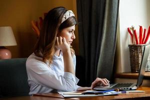 la ragazza lavora al computer in un bar. gli studenti imparano in linea. blogger. giovane scrittrice caucasica che digita sul computer portatile. attraente imprenditrice utilizzando un computer portatile durante una pausa. foto