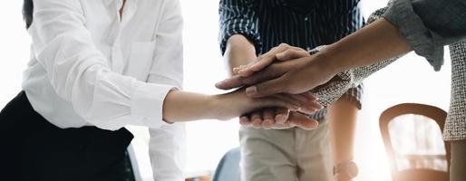 primo piano giovani uomini d'affari che uniscono le mani. pila di mani. concetto di unità e lavoro di squadra. foto