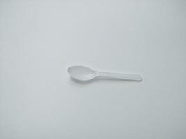 cucchiaio di plastica bianco sfondo bianco dà il concetto di plastica usa e getta che inquina l'ambiente. influenzando il riscaldamento globale foto