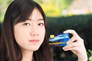 primo piano giovane donna in possesso di carta di credito foto