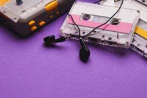 lettore di cassette con auricolari e cassette su sfondo viola. copia spazio per il testo. foto