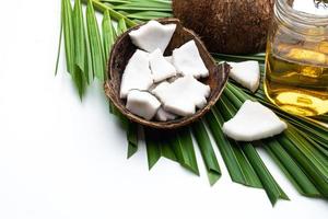 carne di cocco e olio di cocco in bottiglia di vetro su foglia di cocco. foto