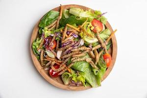 insalata di verdure con bruco di bambù fritto in una ciotola di legno. foto