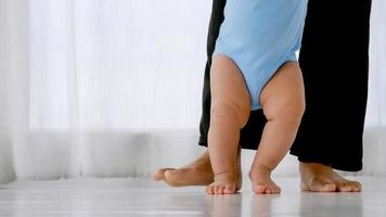 piccolo bambino che impara a camminare con il supporto e la cura della madre. foto