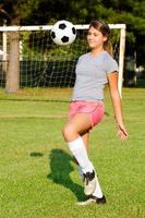 ragazza adolescente giocoleria pallone da calcio foto
