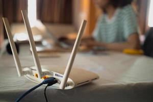 una donna sta lavorando a casa utilizzando un modem router, collegando Internet al suo laptop. foto