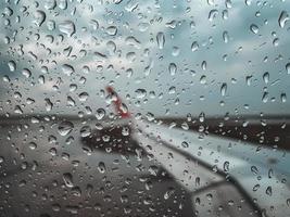 goccia di pioggia al finestrino dell'aereo prima del decollo durante la stagione dei monsoni. foto