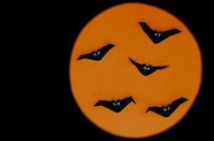 l'origami di halloween o la piegatura della carta di pipistrelli isolati su sfondo arancione e nero. foto