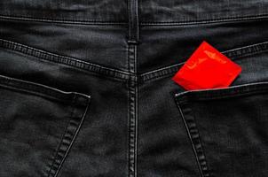 preservativo nella parte posteriore della tasca dei jeans per il sesso anale sicuro, la salute sessuale mondiale e il concetto di giornata contro l'aids. foto